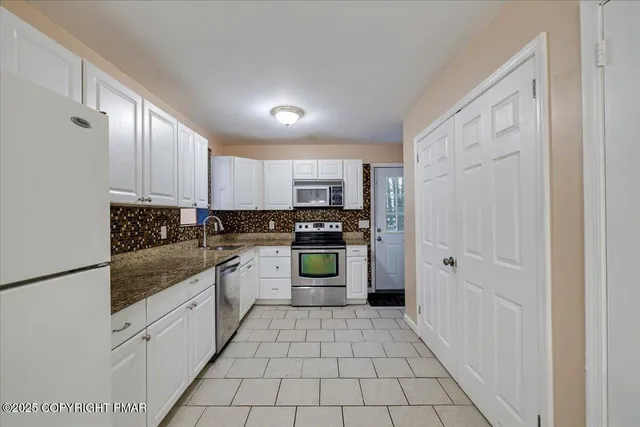 a kitchen with stainless steel appliances granite countertop a refrigerator and a stove top oven