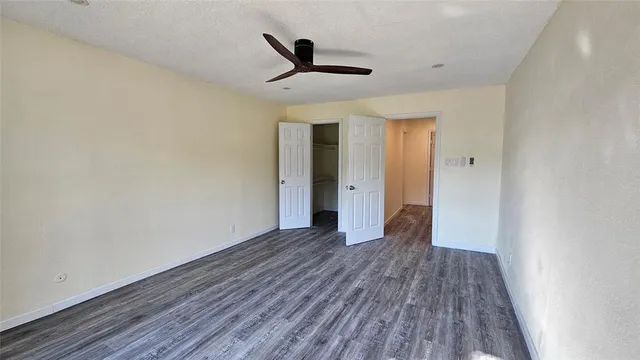 a view of a room with wooden floor and a ceiling fan