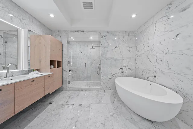 a large spacious bathroom with a tub sink shower and mirror