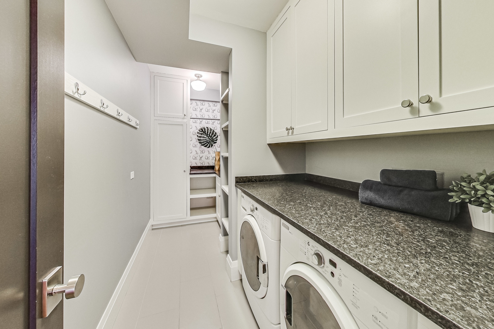 55 West Delaware Place, Unit 620 Chicago, IL 60610 - Photo 41 of 48 a kitchen with granite countertop white cabinets and washer