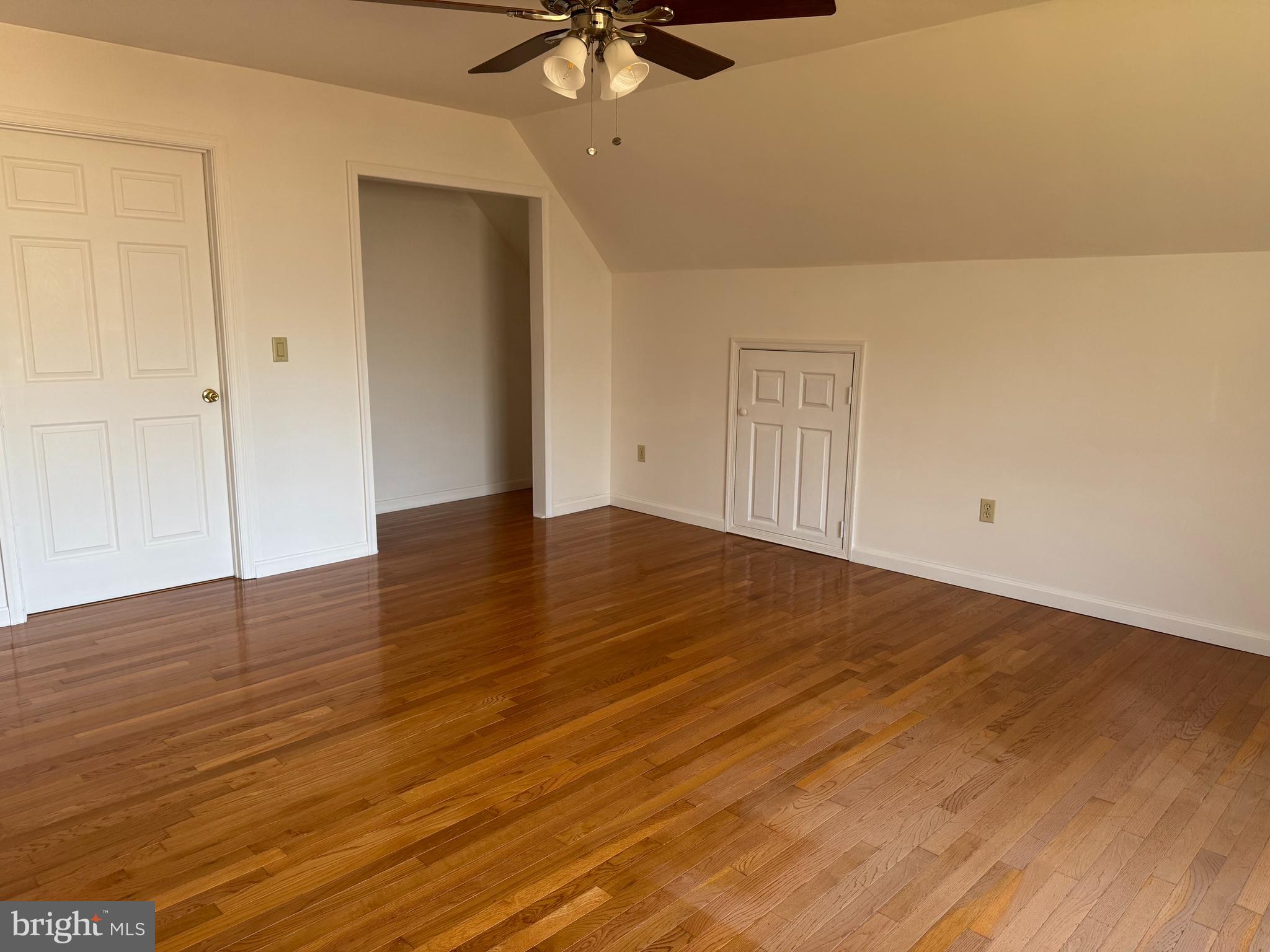 26759 Old State Road Crisfield, MD 21817 - Photo 11 of 17 an empty room with wooden floor and chandelier fan