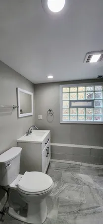 a bathroom with a double vanity sink toilet and a mirror