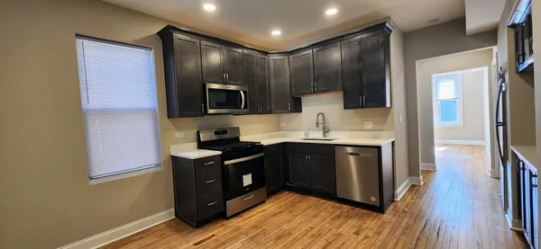 a view of empty room with wooden floor and window