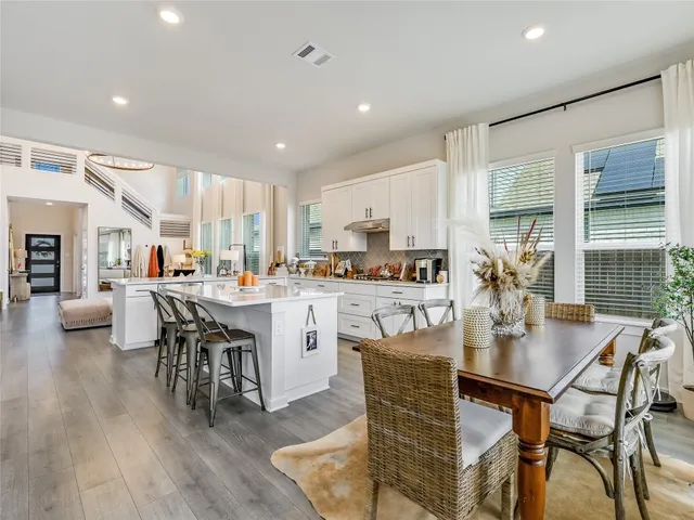 a open dining room with stainless steel appliances kitchen island granite countertop a dining table chairs and view living room