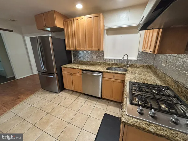 a kitchen with stainless steel appliances granite countertop a stove refrigerator and sink