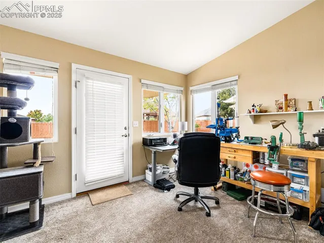 a view of a workspace with furniture and a window