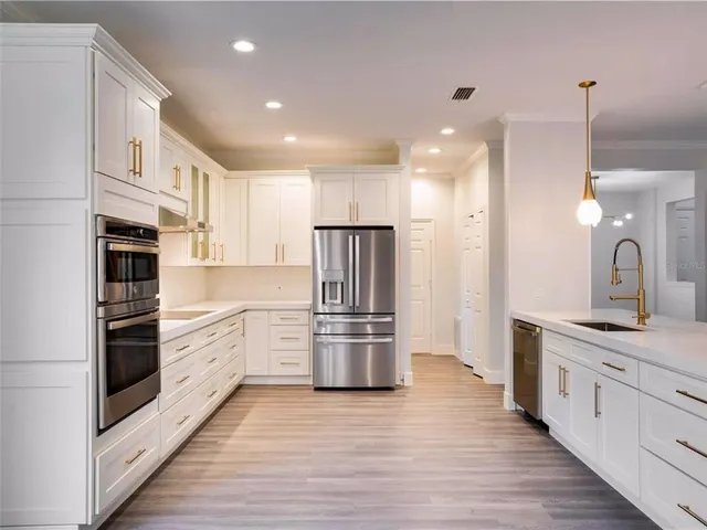 a kitchen with granite countertop a refrigerator and a sink