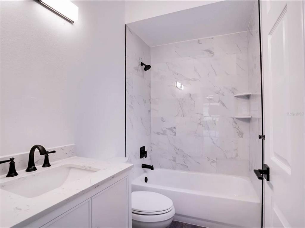 7724 US Open Loop Lakewood Ranch, FL 34202 - Photo 14 of 40 a bathroom with a bathtub shower sink vanity mirror and toilet