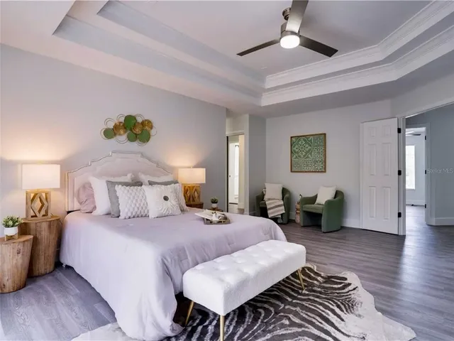 a spacious bedroom with a bed a couch and a chandelier