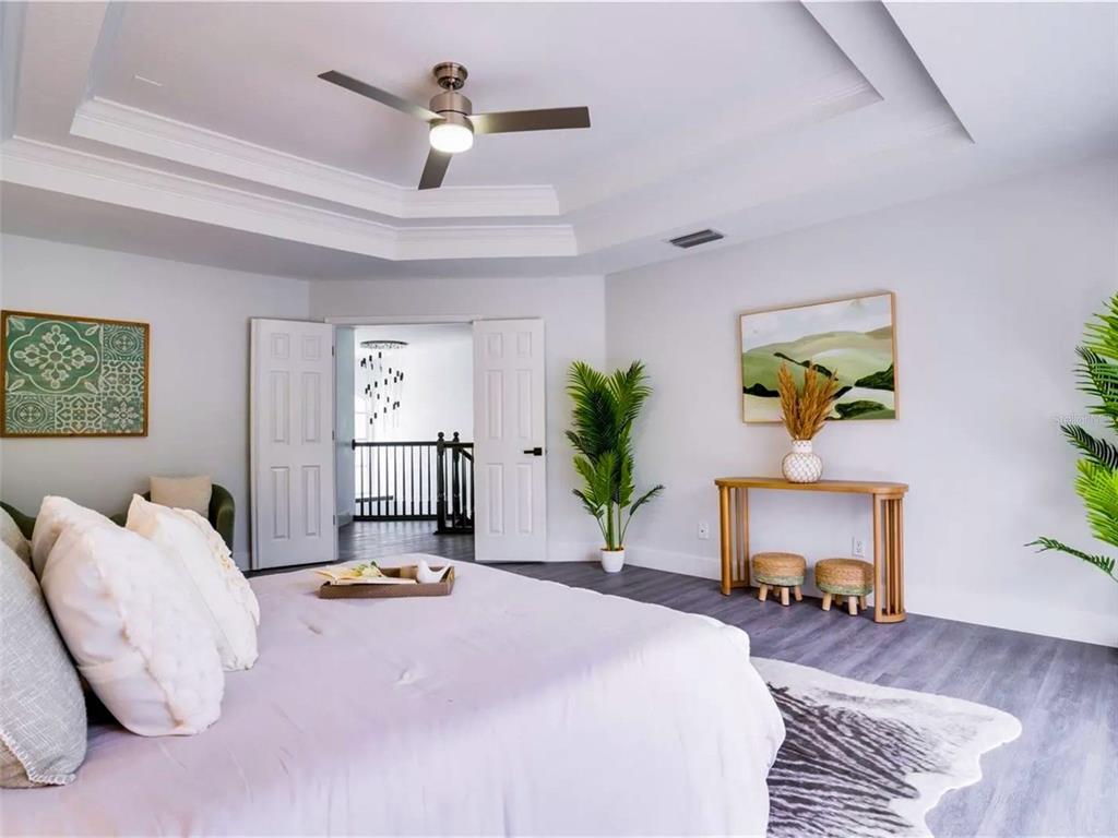 7724 US Open Loop Lakewood Ranch, FL 34202 - Photo 18 of 40 a bedroom with a bed and a chandelier