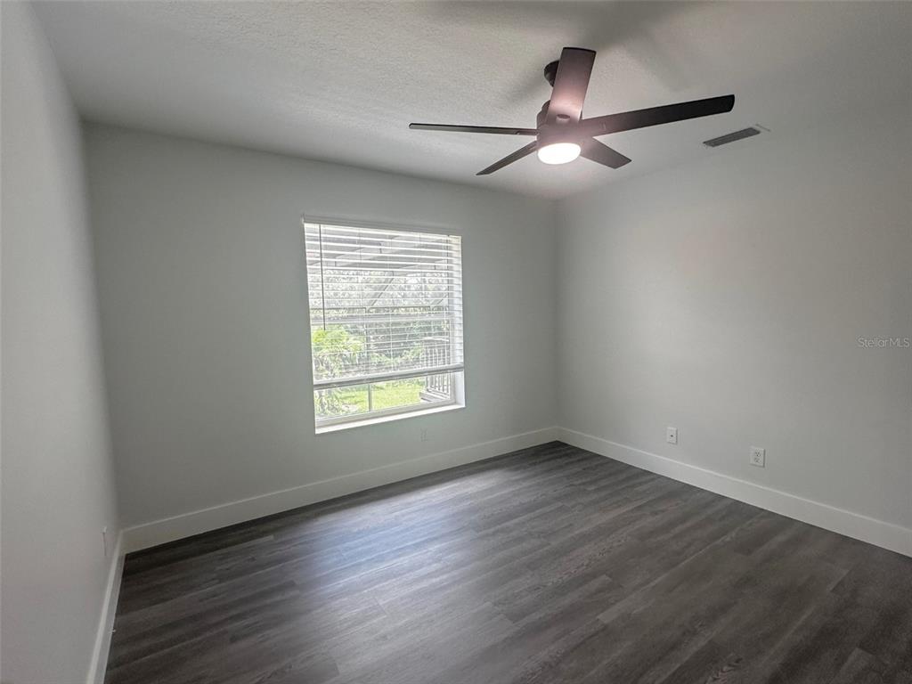 7724 US Open Loop Lakewood Ranch, FL 34202 - Photo 27 of 40 an empty room with wooden floor fan and windows