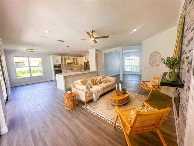 a living room with furniture a window and wooden floor