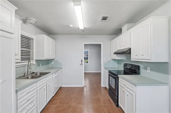 a kitchen with granite countertop a sink stainless steel appliances and cabinets