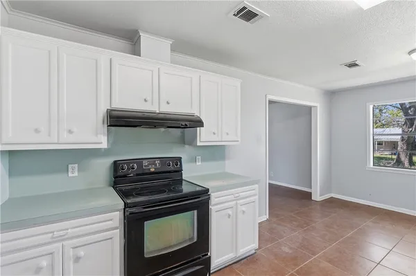 a kitchen with granite countertop white cabinets and appliances