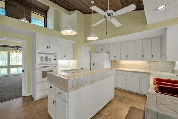 a kitchen that has a lot of cabinets in it and wooden floors