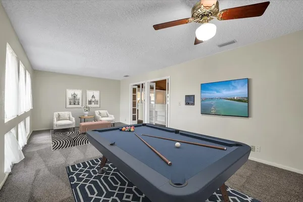 a room with furniture pool table and windows