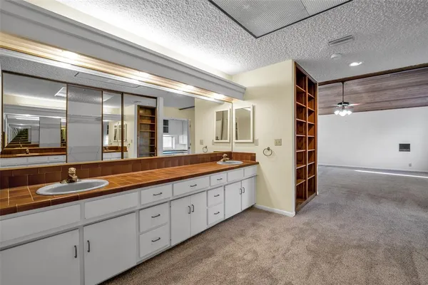 a spacious bathroom with double vanity and mirrors