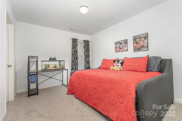 a spacious bedroom with a bed and dresser