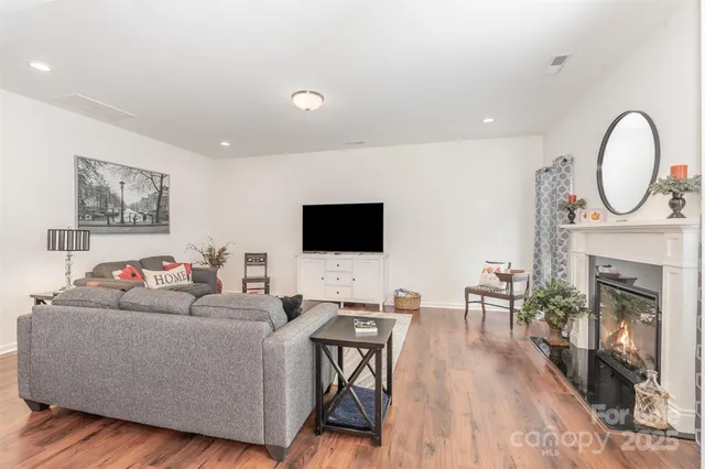 a living room with furniture a fireplace and a flat screen tv