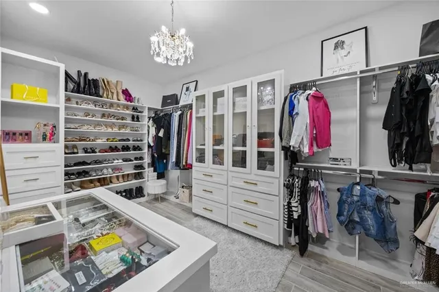 a view of walk in closet with clothes and shoes
