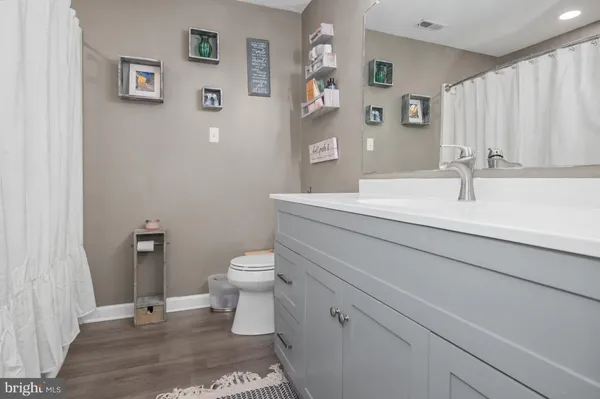 a bathroom with a sink a toilet and a large mirror