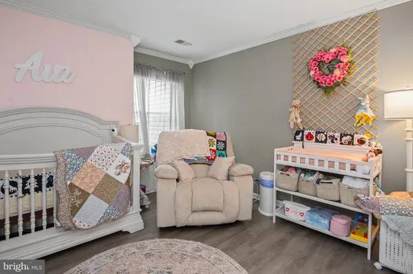 a living room with furniture and a baby crib