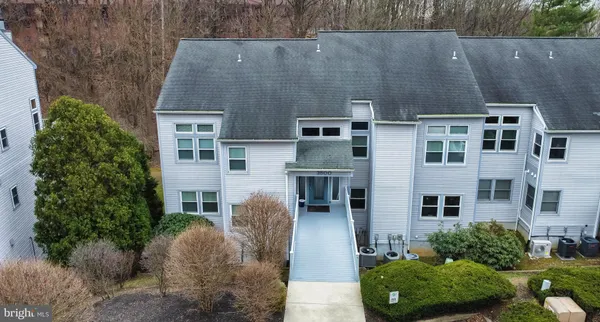 an aerial view of a house with a yard and large tree