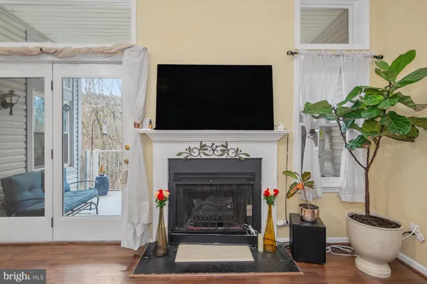 a living room with a fireplace a flat screen tv and a potted plant