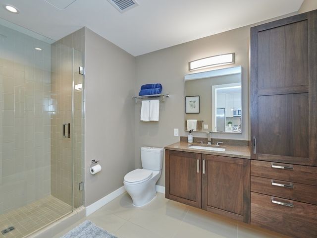 a spacious bathroom with a toilet a sink and mirror