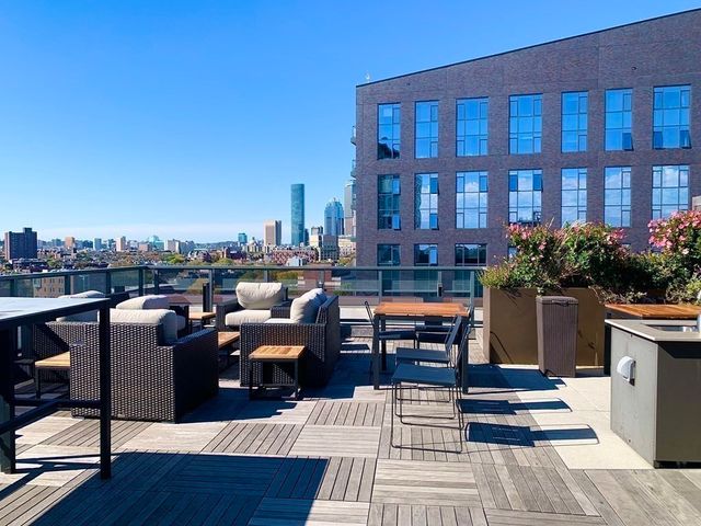 a view of a rooftop deck patio and outdoor seating