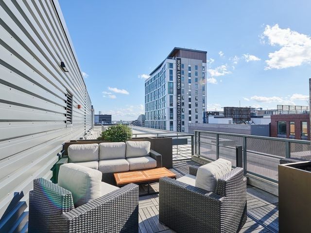 a roof deck with couch and chairs