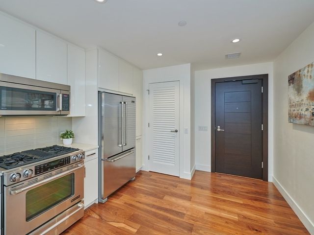 a kitchen with stainless steel appliances granite countertop a refrigerator and a stove top oven