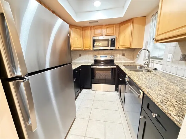 a kitchen with stainless steel appliances a refrigerator sink and microwave
