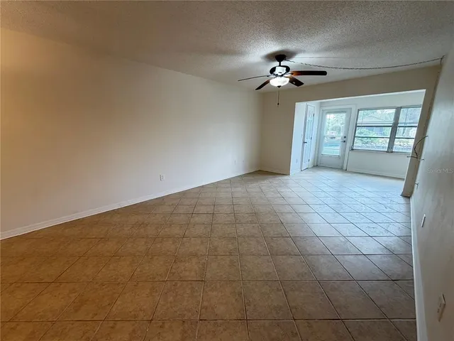 a view of a livingroom with a ceiling fan and window