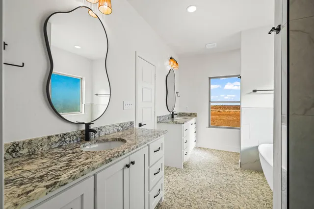 a bathroom with a granite countertop sink and a mirror