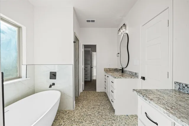 a bathroom with a granite countertop sink a toilet and shower