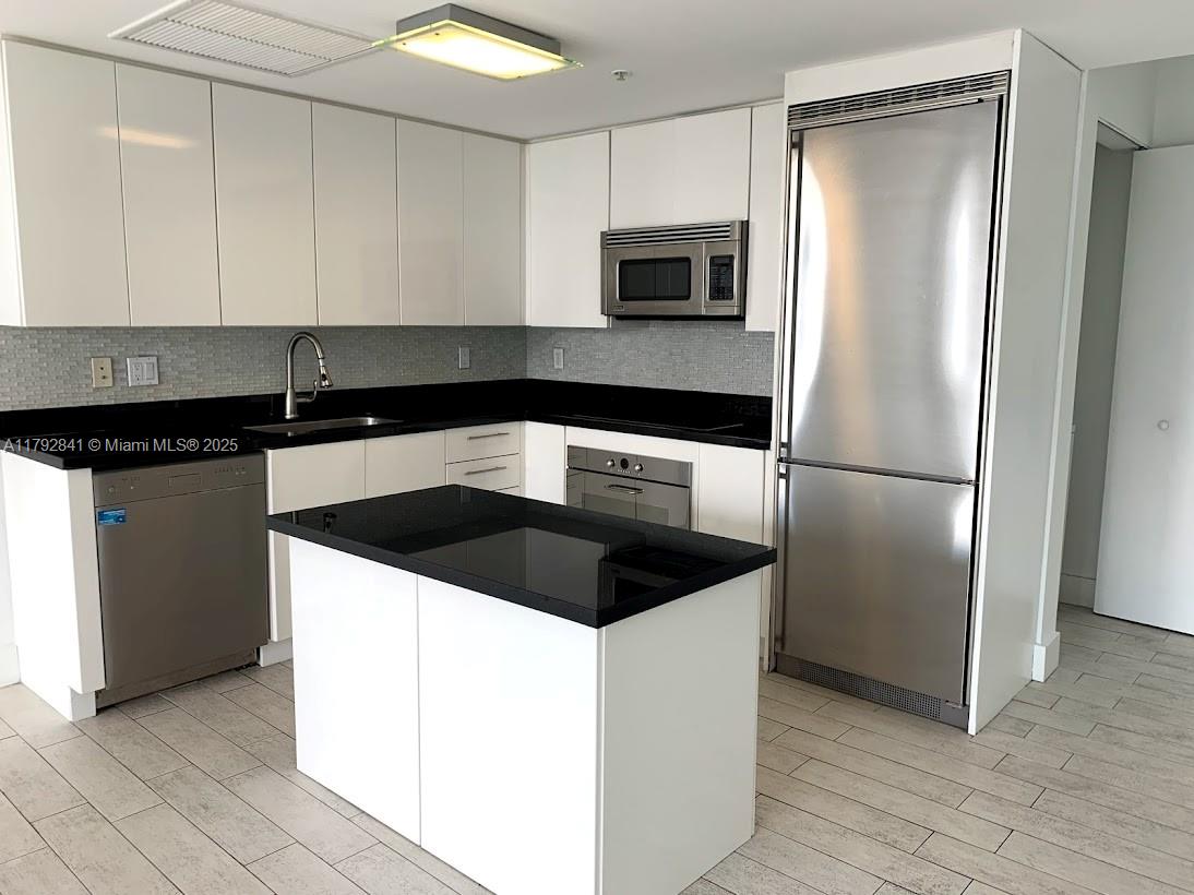 92 Southwest 3rd Street, Unit 3903 Miami, FL 33130 - Photo 1 of 25 a kitchen with granite countertop a sink and a refrigerator