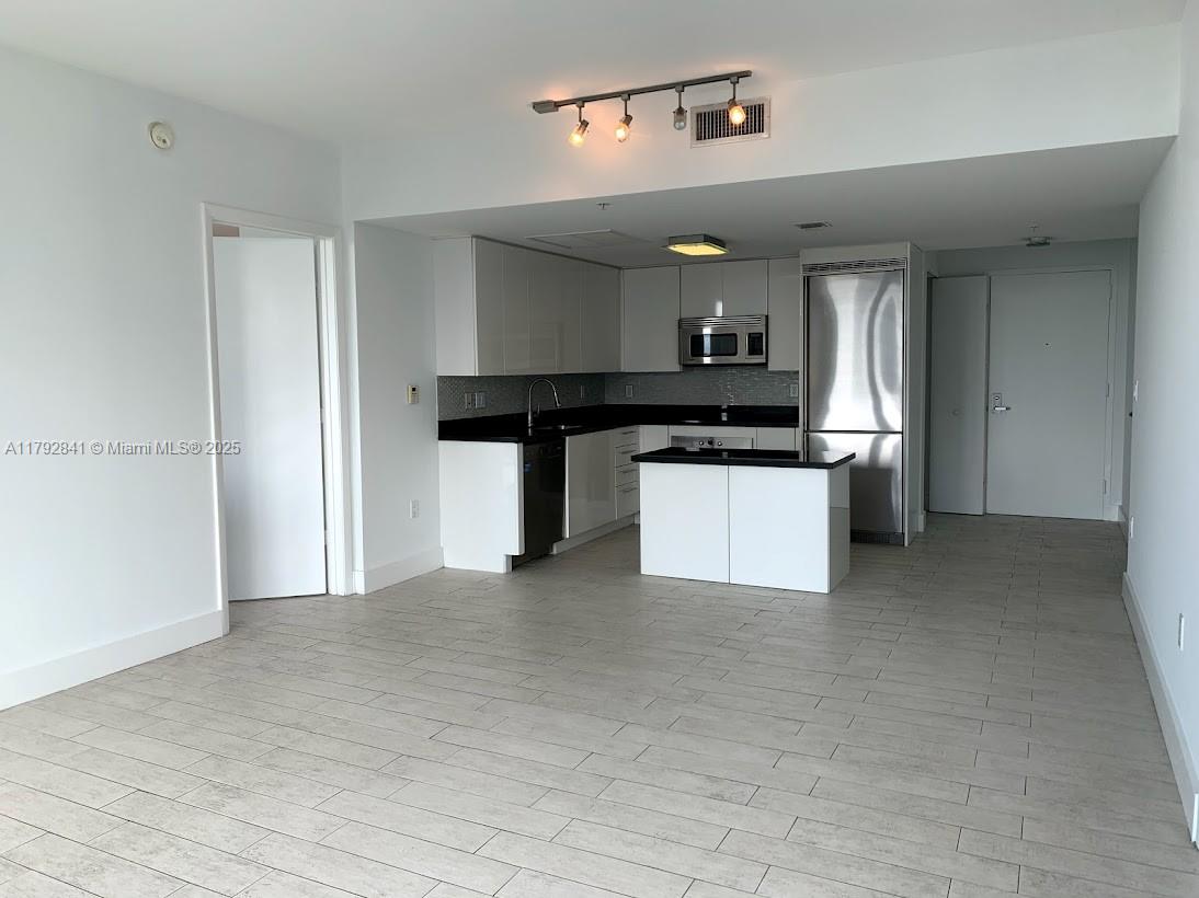 92 Southwest 3rd Street, Unit 3903 Miami, FL 33130 - Photo 2 of 25 a kitchen with a refrigerator a stove and cabinets