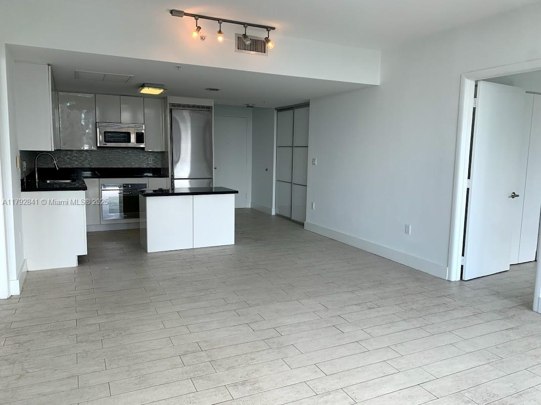 92 Southwest 3rd Street, Unit 3903 Miami, FL 33130 - Photo 3 of 25 a kitchen with stainless steel appliances kitchen island sink refrigerator and stove