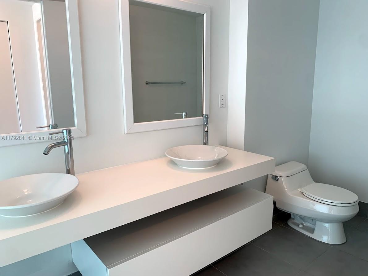 92 Southwest 3rd Street, Unit 3903 Miami, FL 33130 - Photo 8 of 25 a bathroom with a sink a toilet a mirror and shower