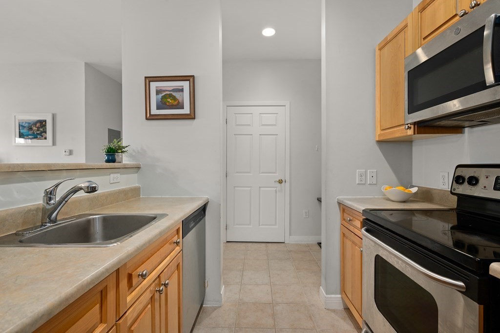 8 Walnut Street, Unit 406 Peabody, MA 01960 - Photo 14 of 31 a kitchen with stainless steel appliances granite countertop a sink stove and microwave