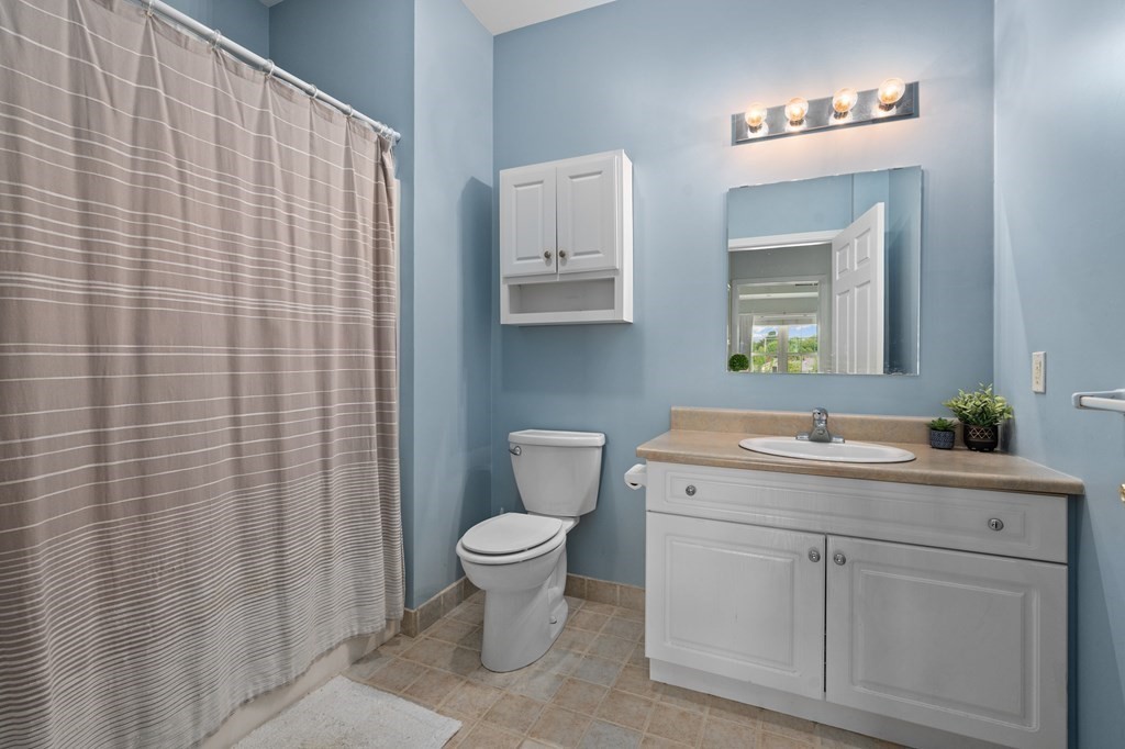 8 Walnut Street, Unit 406 Peabody, MA 01960 - Photo 16 of 31 a bathroom with a sink a toilet and mirror