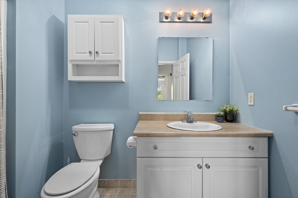 8 Walnut Street, Unit 406 Peabody, MA 01960 - Photo 17 of 31 a bathroom with a toilet sink and mirror