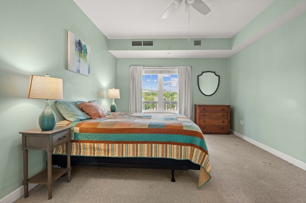 8 Walnut Street, Unit 406 Peabody, MA 01960 - Photo 20 of 31 a bedroom with a bed window and a chandelier