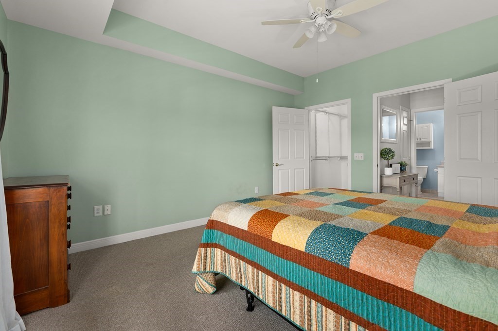 8 Walnut Street, Unit 406 Peabody, MA 01960 - Photo 21 of 31 a bedroom with a bed and a chandelier