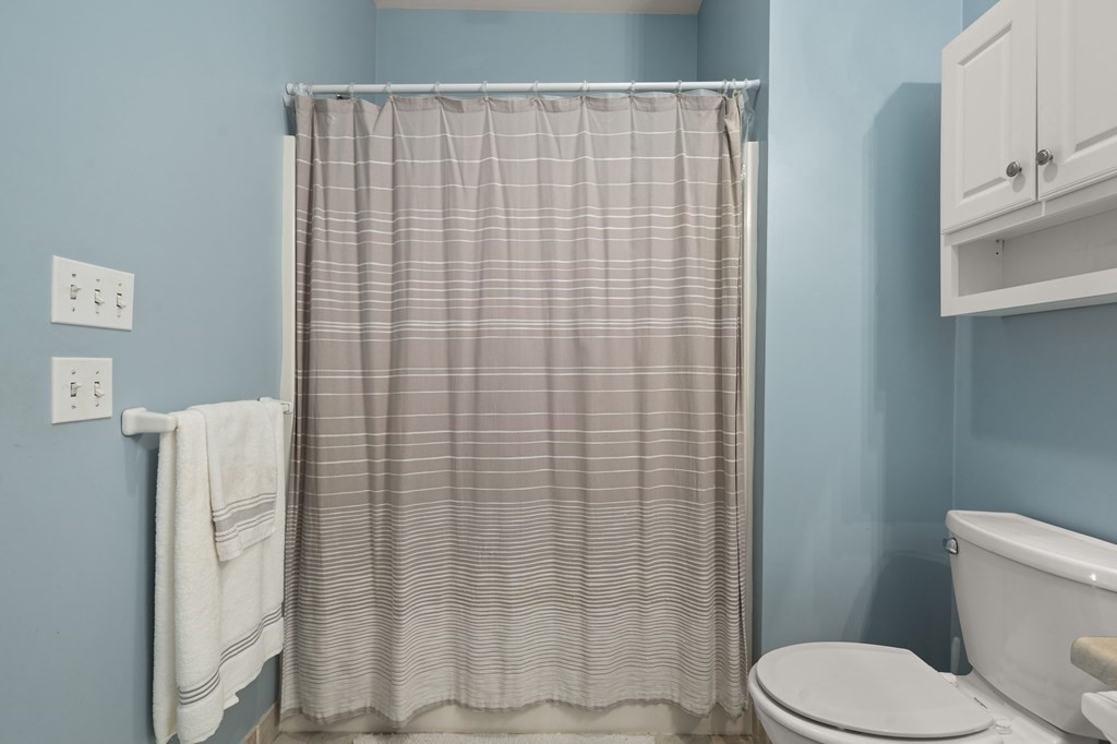 8 Walnut Street, Unit 406 Peabody, MA 01960 - Photo 25 of 31 a white toilet sitting next to a shower curtain