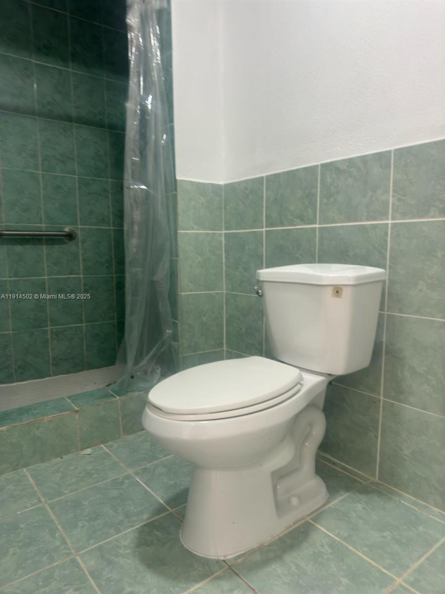 12539 Southwest 259th Street, Unit B Homestead, FL 33032 - Photo 8 of 11 a bathroom with a toilet and a shower