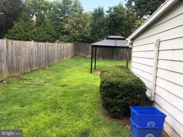 a backyard of a house with plants and wooden fence