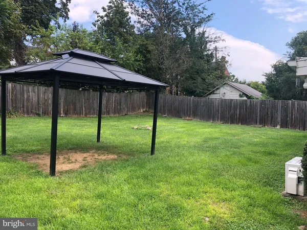 a backyard of a house with swimming pool and wooden fence