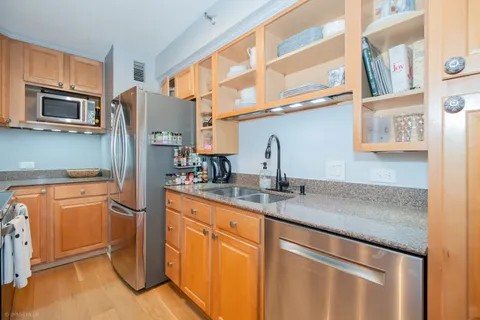 a kitchen with stainless steel appliances granite countertop a refrigerator and a sink